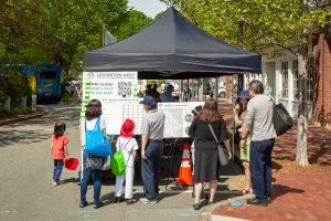 Adults and children view posters at Discovery Day